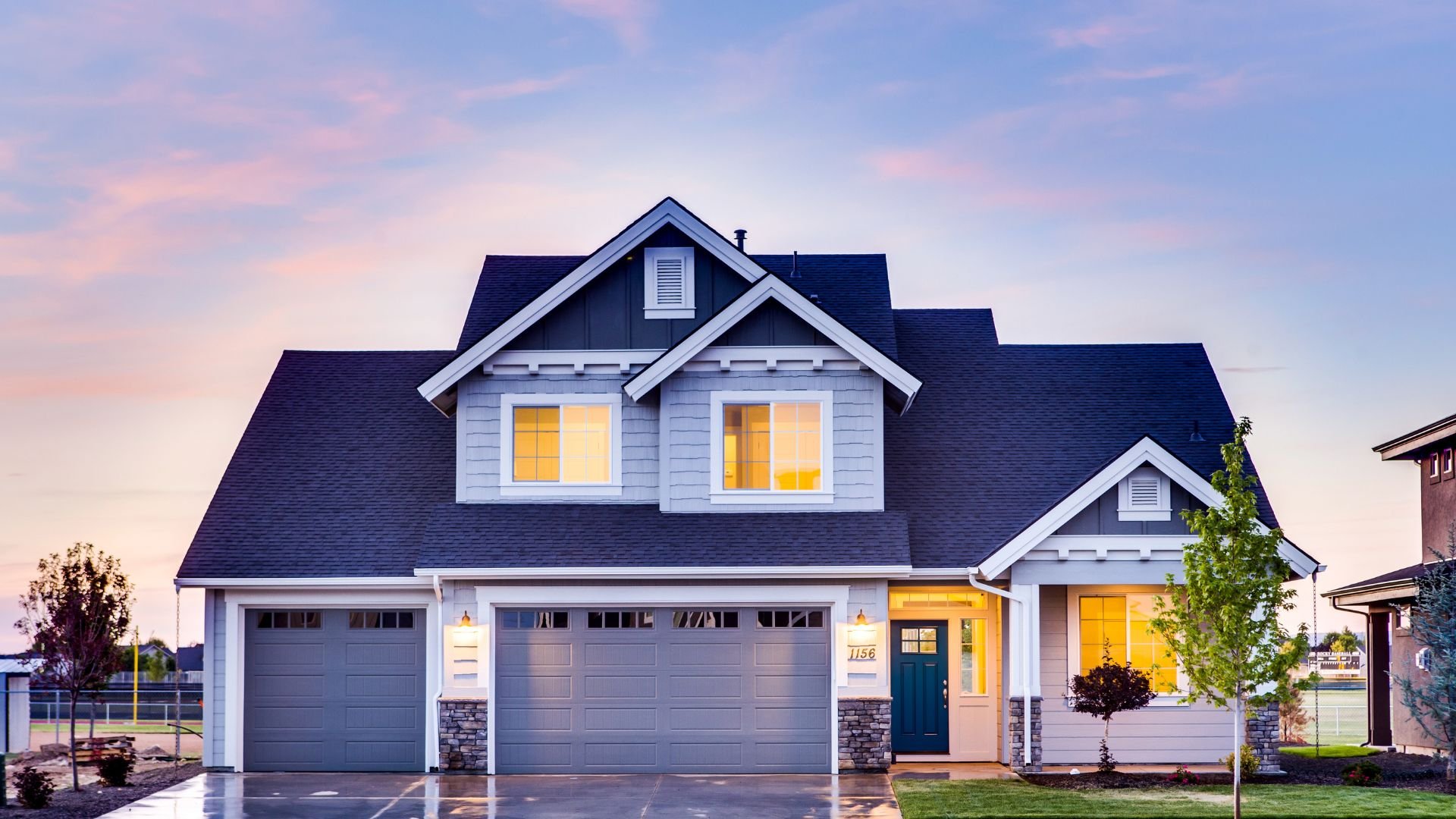 Modern two-story house with three-car garage at twilight
