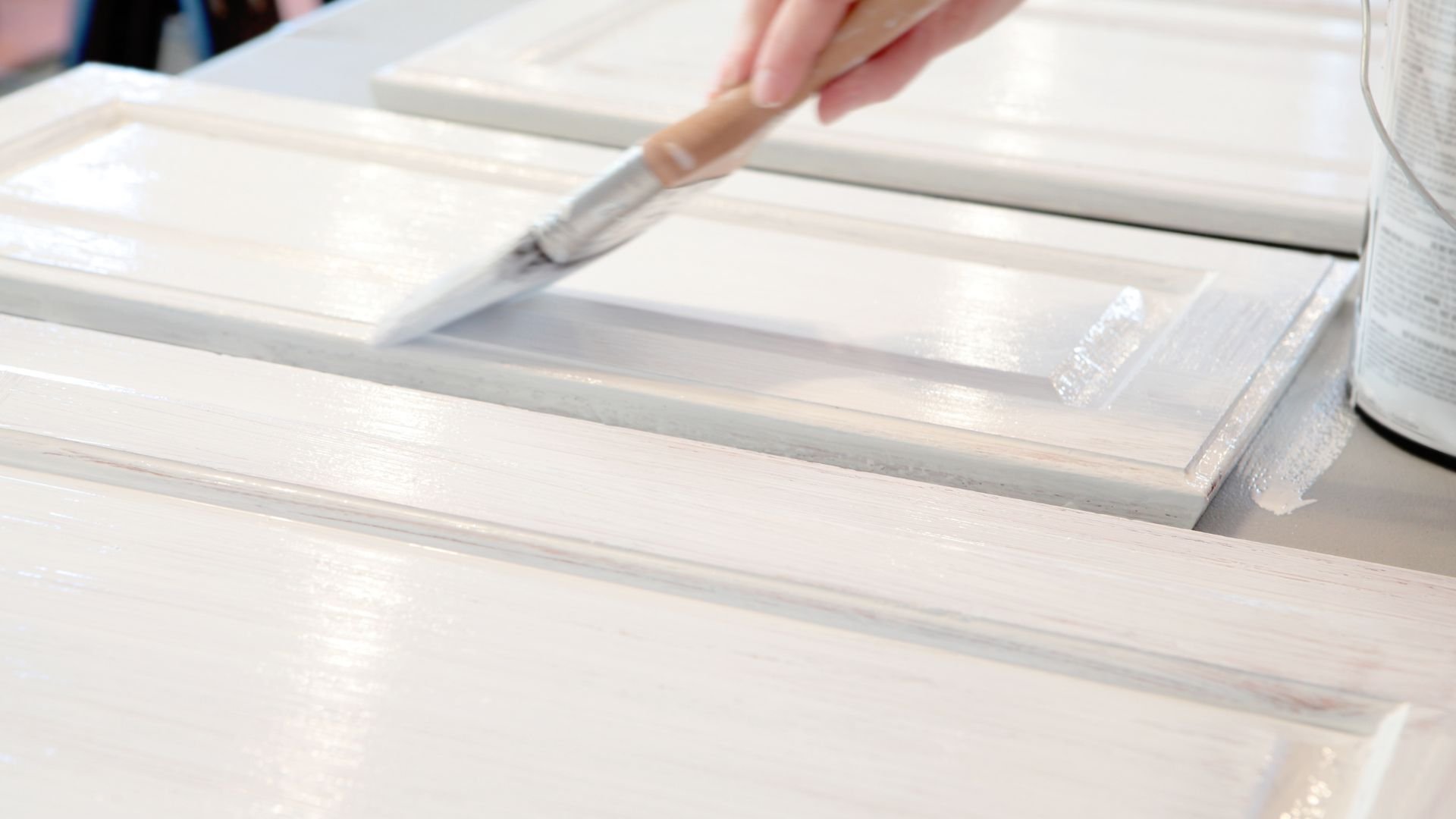 Hand using utility knife to cut white material or surface