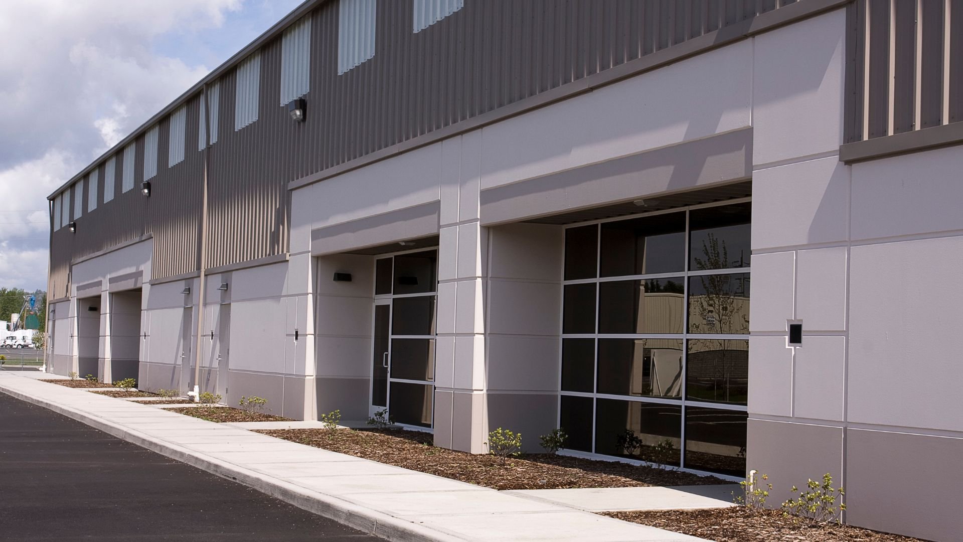 Modern industrial building with glass doors and gray metal siding